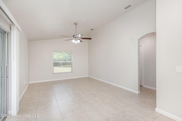 1094 Locust Ave NW, Palm Bay, FL 32907 - unfurnished room featuring arched walkways, a ceiling fan, vaulted ceiling, light tile patterned floors, and baseboards