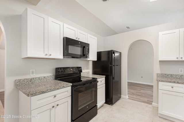 1094 Locust Ave NW, Palm Bay, FL 32907 - kitchen with black appliances, arched walkways, white cabinets, light stone counters, and baseboards