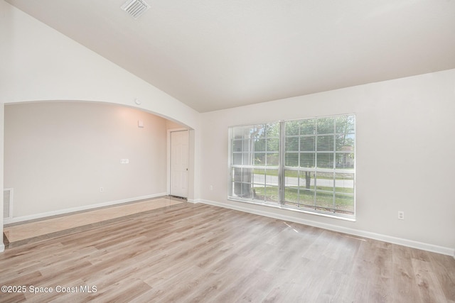 1094 Locust Ave NW, Palm Bay, FL 32907 - spare room featuring arched walkways, light wood finished floors, lofted ceiling, and baseboards