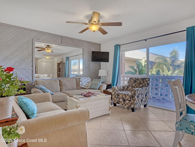 3150 N Atlantic Ave Unit 4-990, Cocoa Beach, FL 32931 - living room with ceiling fan, wooden walls, and light tile patterned floors