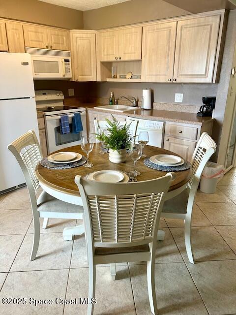 3150 N Atlantic Ave Unit 4-990, Cocoa Beach, FL 32931 - kitchen with white appliances, a sink, light brown cabinets, and light tile patterned floors