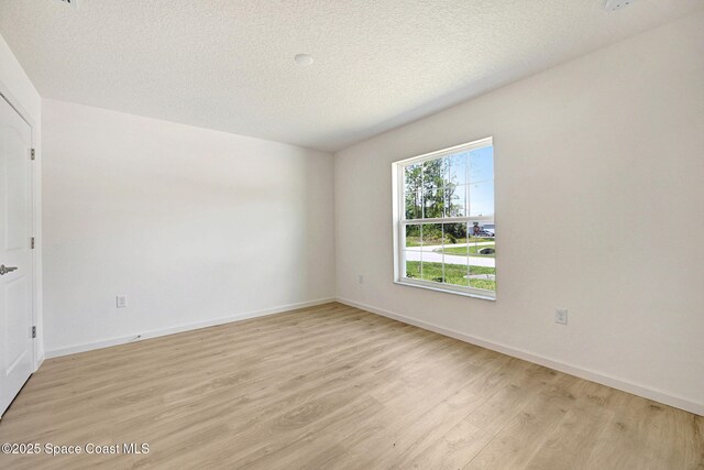 2597 Galiano Ave, Palm Bay, FL 32908 - spare room with light wood-style flooring, a textured ceiling, and baseboards