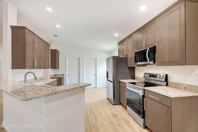 2597 Galiano Ave, Palm Bay, FL 32908 - kitchen with appliances with stainless steel finishes, light wood-style flooring, a sink, recessed lighting, and a peninsula