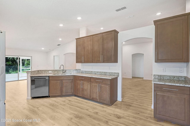 2597 Galiano Ave, Palm Bay, FL 32908 - kitchen with stainless steel dishwasher, a sink, arched walkways, light wood finished floors, and light stone counters