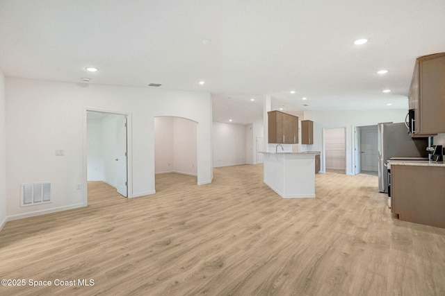 2597 Galiano Ave, Palm Bay, FL 32908 - unfurnished living room featuring recessed lighting, light wood-style floors, baseboards, and arched walkways