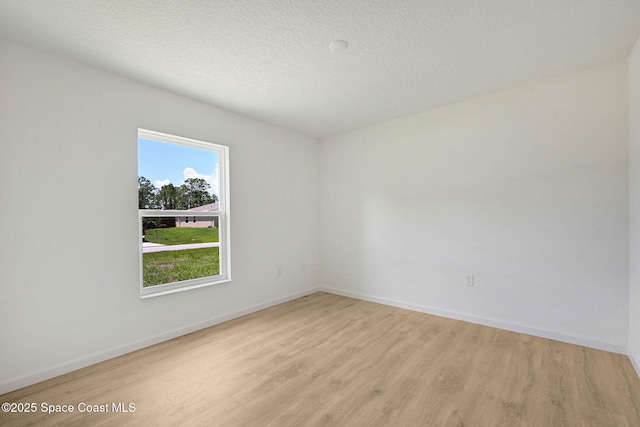 2597 Galiano Ave, Palm Bay, FL 32908 - unfurnished room with light wood-type flooring, baseboards, and a textured ceiling