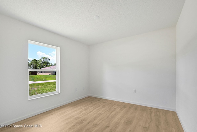 2597 Galiano Ave, Palm Bay, FL 32908 - unfurnished room featuring light wood-style floors, baseboards, and a textured ceiling