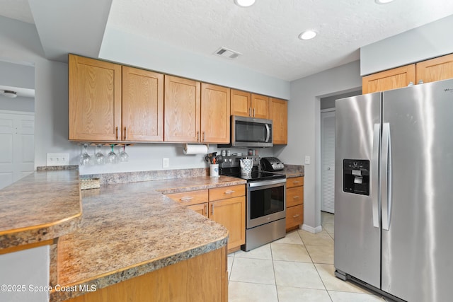 1250 York Cir, Melbourne, FL 32904 - kitchen with appliances with stainless steel finishes, light tile patterned floors, a peninsula, recessed lighting, and a textured ceiling