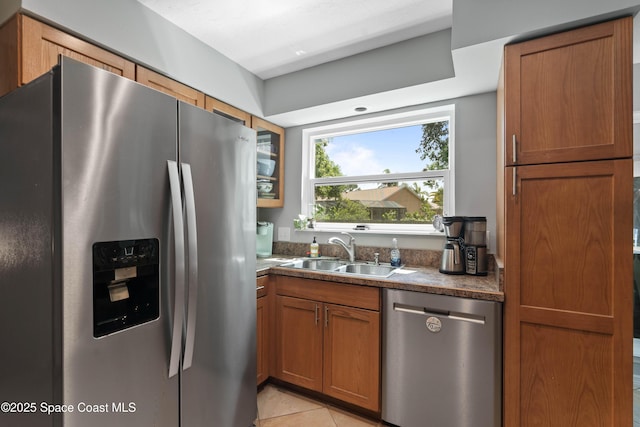 1250 York Cir, Melbourne, FL 32904 - kitchen featuring stainless steel appliances, a sink, dark countertops, brown cabinets, and light tile patterned floors