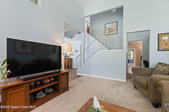 1250 York Cir, Melbourne, FL 32904 - living room featuring high vaulted ceiling, stairway, light colored carpet, and baseboards