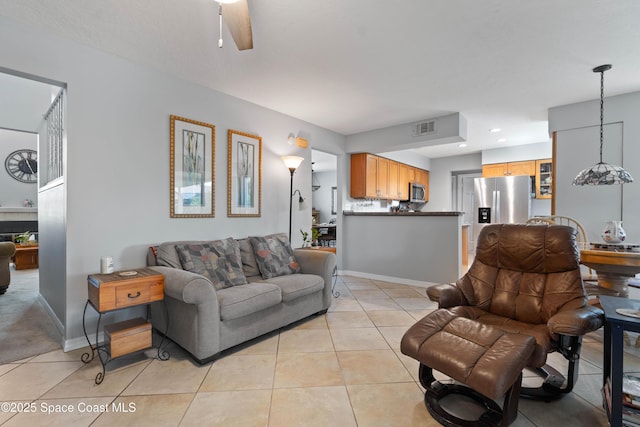 1250 York Cir, Melbourne, FL 32904 - living area with light tile patterned floors, a ceiling fan, and baseboards