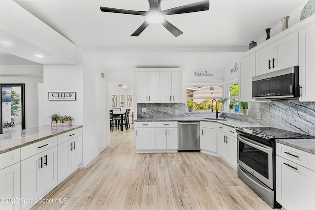 996 S Wickham Rd, West Melbourne, FL 32904 - kitchen with stainless steel appliances, ceiling fan, light stone countertops, tasteful backsplash, and white cabinets