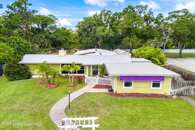 996 S Wickham Rd, West Melbourne, FL 32904 - view of front of house with a chimney, metal roof, and view of scattered trees