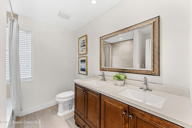 520 Bahama Dr, Indian Harbour Beach, FL 32937 - bathroom with double vanity, toilet, and baseboards