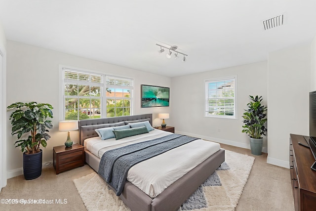 520 Bahama Dr, Indian Harbour Beach, FL 32937 - bedroom featuring baseboards, track lighting, and light colored carpet