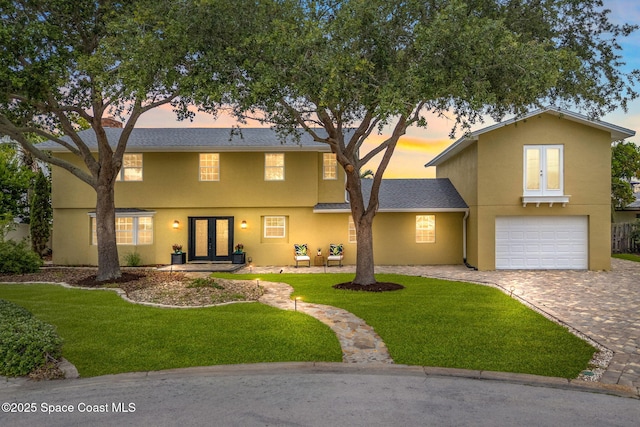520 Bahama Dr, Indian Harbour Beach, FL 32937 - view of front of home featuring french doors, decorative driveway, a front lawn, and stucco siding