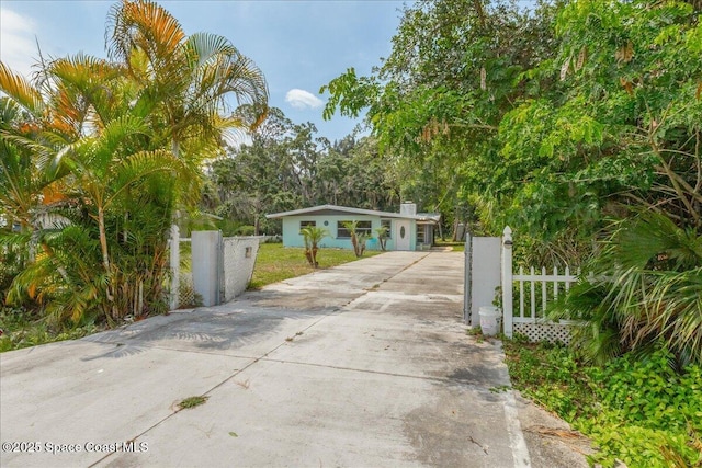 2835 Sunset Rd, Melbourne, FL 32904 - view of front facade with concrete driveway, a fenced front yard, and a gate