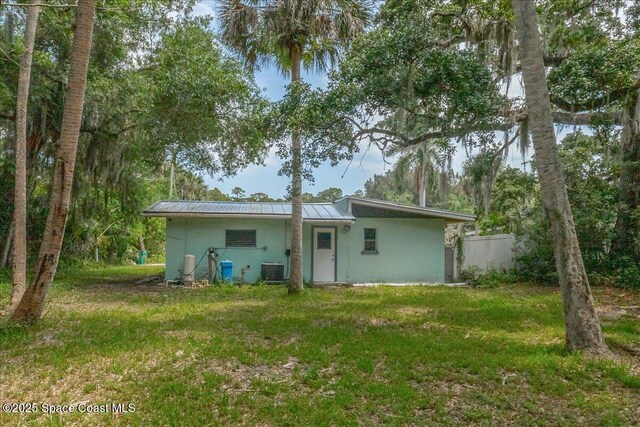 2835 Sunset Rd, Melbourne, FL 32904 - back of house with metal roof, stucco siding, and cooling unit