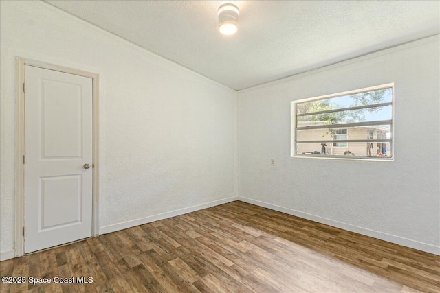2835 Sunset Rd, Melbourne, FL 32904 - unfurnished room with wood finished floors, baseboards, and a textured ceiling