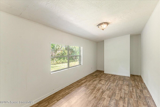 2835 Sunset Rd, Melbourne, FL 32904 - unfurnished room featuring light wood-style flooring, baseboards, and a textured ceiling