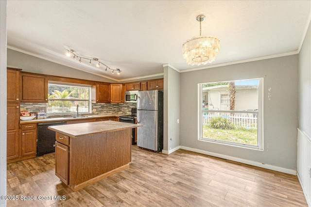 2835 Sunset Rd, Melbourne, FL 32904 - kitchen with black appliances, a sink, decorative backsplash, a chandelier, and a center island
