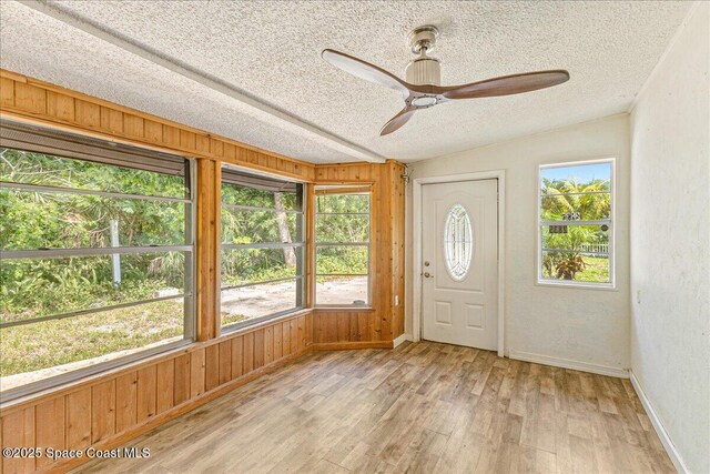 2835 Sunset Rd, Melbourne, FL 32904 - unfurnished sunroom with wood finished floors, a textured ceiling, baseboards, and wood walls