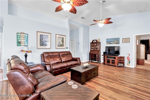 749 Tulip Dr, Sebastian, FL 32958 - living room with a ceiling fan, light wood finished floors, baseboards, and high vaulted ceiling