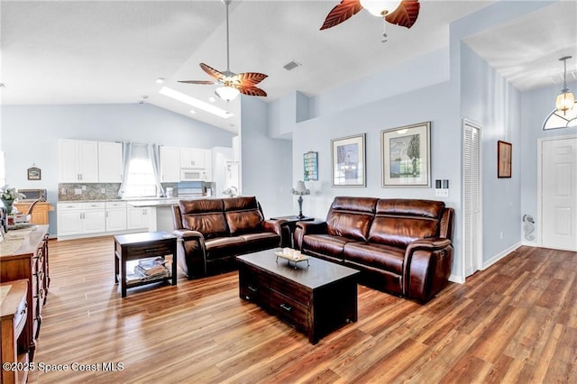 749 Tulip Dr, Sebastian, FL 32958 - living area featuring a ceiling fan, light wood-type flooring, high vaulted ceiling, and baseboards