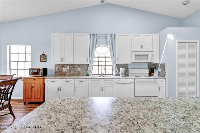 749 Tulip Dr, Sebastian, FL 32958 - kitchen with white appliances, a sink, dark wood-style floors, lofted ceiling, and light stone countertops