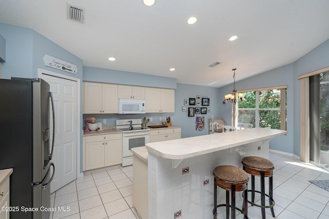 2020 Twelve Oaks Dr SE, Palm Bay, FL 32909 - kitchen featuring white appliances, light tile patterned floors, white cabinets, light countertops, and recessed lighting
