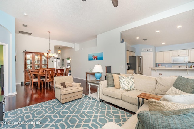 2020 Twelve Oaks Dr SE, Palm Bay, FL 32909 - living area with arched walkways, wood finished floors, a chandelier, baseboards, and recessed lighting