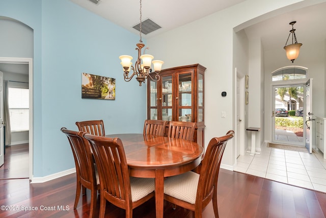 2020 Twelve Oaks Dr SE, Palm Bay, FL 32909 - dining room with a chandelier, wood finished floors, arched walkways, a high ceiling, and baseboards