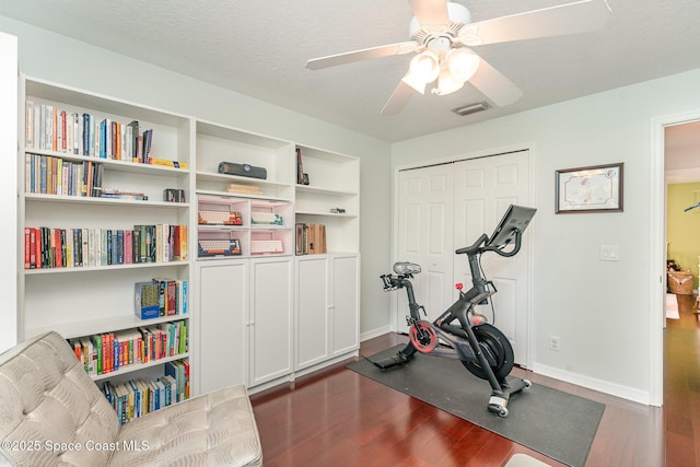 2020 Twelve Oaks Dr SE, Palm Bay, FL 32909 - exercise area with dark wood finished floors, a ceiling fan, and baseboards