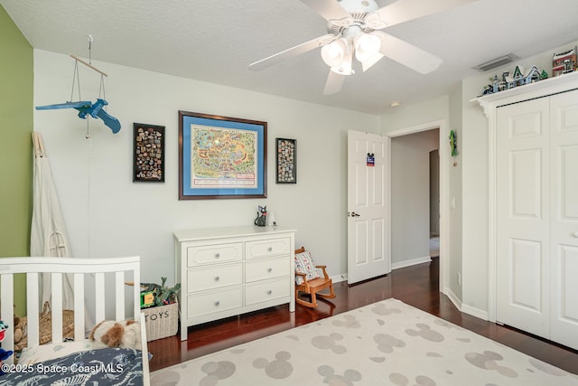 2020 Twelve Oaks Dr SE, Palm Bay, FL 32909 - bedroom with dark wood-style flooring, ceiling fan, a closet, and a crib