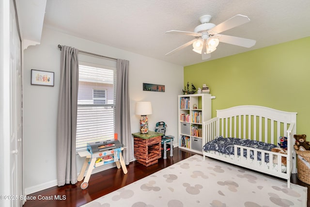 2020 Twelve Oaks Dr SE, Palm Bay, FL 32909 - bedroom with dark wood finished floors, a nursery area, baseboards, and ceiling fan