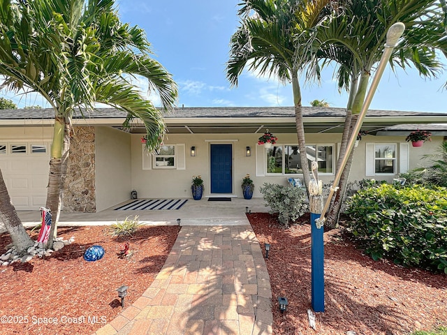 201 Woody Cir, Melbourne Beach, FL 32951 - ranch-style home with stucco siding, a porch, roof with shingles, and a garage