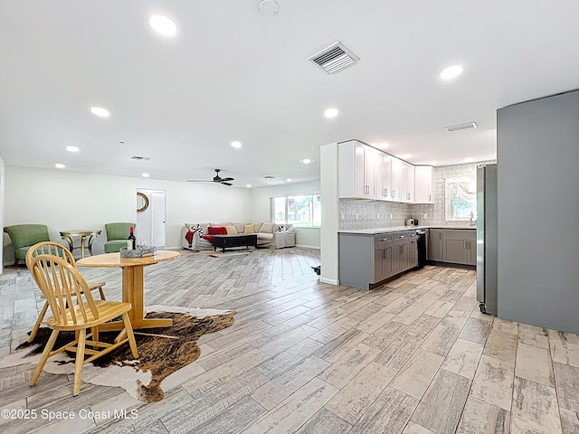 201 Woody Cir, Melbourne Beach, FL 32951 - kitchen featuring gray cabinetry, open floor plan, light wood-style floors, light countertops, and freestanding refrigerator