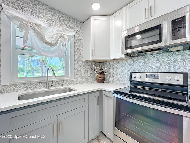 201 Woody Cir, Melbourne Beach, FL 32951 - kitchen featuring stainless steel appliances, a sink, gray cabinets, and tasteful backsplash