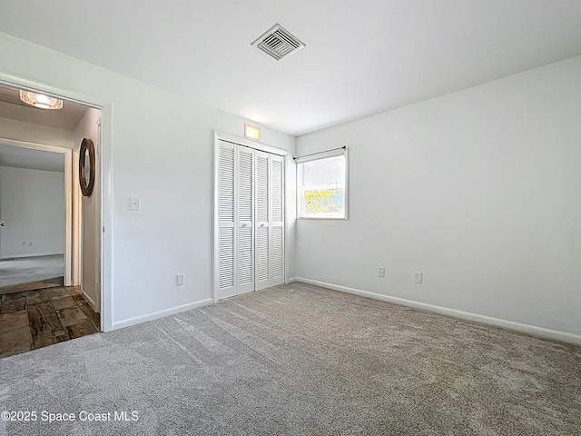 201 Woody Cir, Melbourne Beach, FL 32951 - unfurnished bedroom with carpet floors, baseboards, and a closet