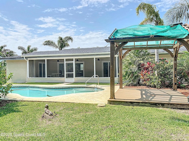 201 Woody Cir, Melbourne Beach, FL 32951 - rear view of property with ceiling fan, a sunroom, a yard, an outdoor pool, and stucco siding