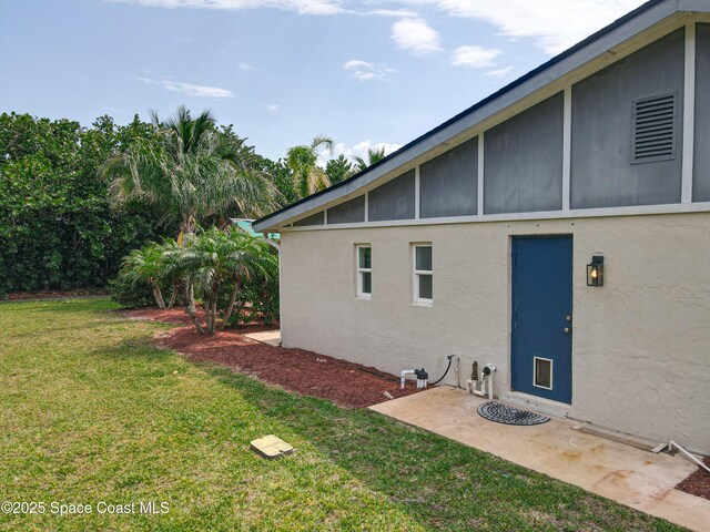 201 Woody Cir, Melbourne Beach, FL 32951 - view of property exterior with stucco siding and a yard
