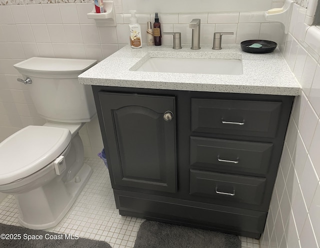 610 Buttonwood Dr, Merritt Island, FL 32953 - half bath with tile walls, vanity, tile patterned floors, toilet, and backsplash