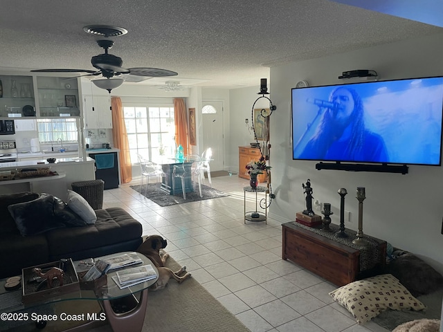 610 Buttonwood Dr, Merritt Island, FL 32953 - living room featuring light tile patterned flooring, a textured ceiling, a ceiling fan, and baseboards