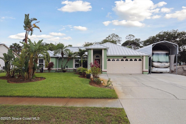 4625 Curtis Blvd, Cocoa, FL 32927 - view of front of home with a carport, metal roof, an attached garage, a front yard, and driveway