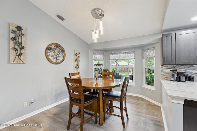 4625 Curtis Blvd, Cocoa, FL 32927 - dining area with vaulted ceiling, light wood-style flooring, baseboards, and a chandelier