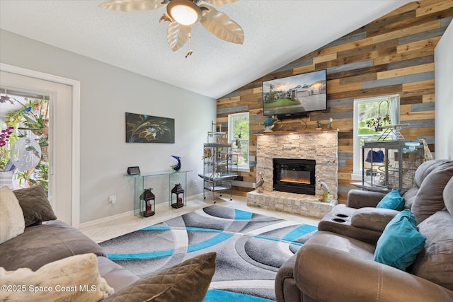 4625 Curtis Blvd, Cocoa, FL 32927 - living room featuring vaulted ceiling, wood walls, ceiling fan, a stone fireplace, and baseboards