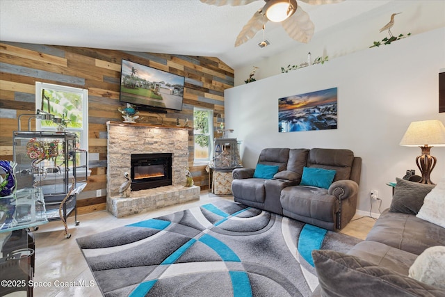 4625 Curtis Blvd, Cocoa, FL 32927 - tiled living room featuring wood walls, vaulted ceiling, ceiling fan, a fireplace, and a textured ceiling