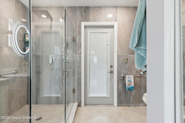 4625 Curtis Blvd, Cocoa, FL 32927 - bathroom featuring tile patterned flooring, toilet, a stall shower, and tile walls
