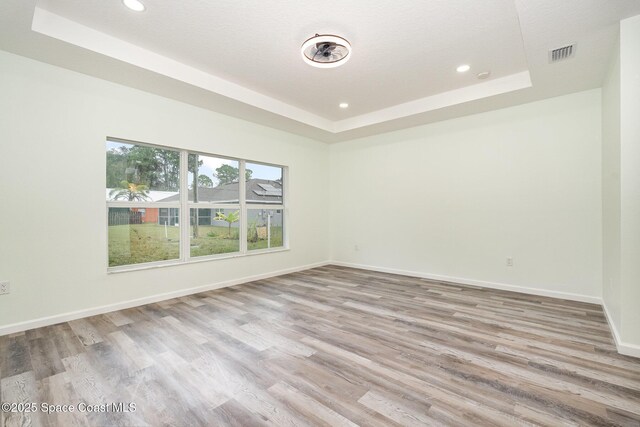 123 Garylind St SW, Palm Bay, FL 32908 - unfurnished room with a raised ceiling, recessed lighting, wood finished floors, and baseboards