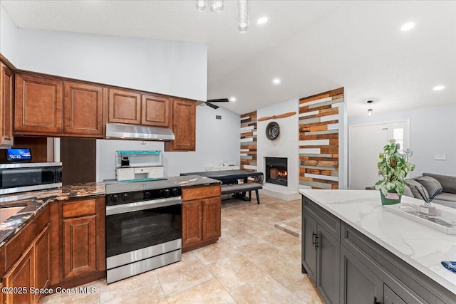 2350 Fallon Blvd NE, Palm Bay, FL 32907 - kitchen with electric range, under cabinet range hood, open floor plan, stainless steel microwave, and light stone countertops